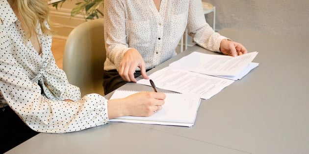 women-signing-documents