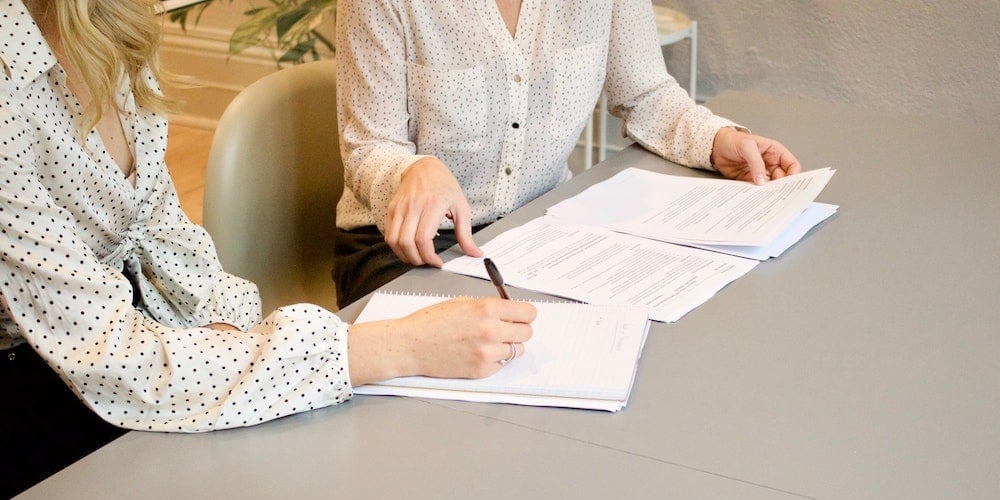 women-signing-documents